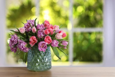 Pencerenin karşısındaki vazoda duran bir buket güzel lale.