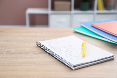 Ev ödevi. Matematik alıştırmalı defter ve tahta masa üzerindeki kalem, yakın plan. Metin için boşluk
