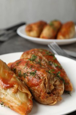 Gri masada servis edilen lezzetli lahana dürümleri, yakın plan.