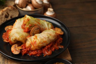 Ahşap masada servis edilen mantarlı lahana dürümleri. Metin için boşluk