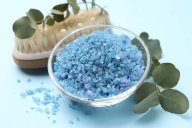 Cam kasede deniz tuzu, fırça ve okaliptüs dalları açık mavi arka planda, yakın plan