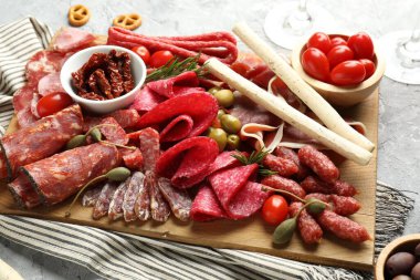 Farklı pişirilmiş et, sosis, zeytin ve domatesli şarküteri tahtası, yakın plan.