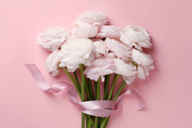 Pembe arka planda bir buket güzel ranunculus çiçeği, üst manzara.