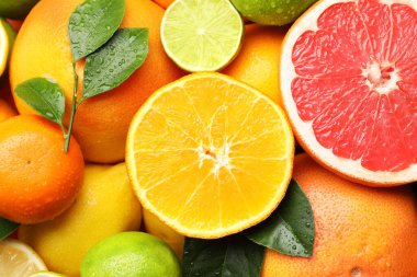 Farklı olgun narenciye meyveleri ve yaprakları arka plan olarak, yakın plan