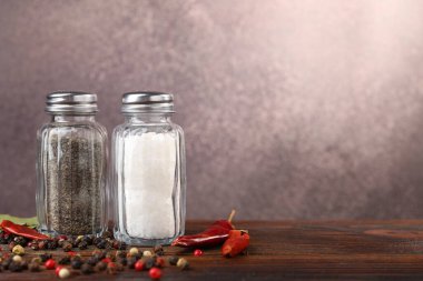 Tuz ve biber karıştırıcı ve ahşap masada baharatlar bulanık arka planda. Metin için boşluk