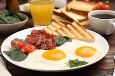 Yağda yumurta ve pastırma ile nefis bir kahvaltı, ahşap masada servis edilir, yakın plan.