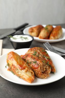 Gri masada servis edilen lezzetli lahana dürümleri, yakın plan.