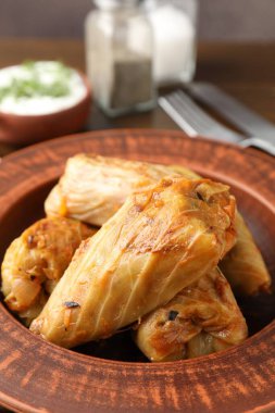 Tahta masada servis edilen lezzetli lahana dürümleri, yakın plan.