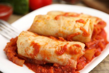 Tahta masada servis edilen lezzetli lahana dürümleri, yakın plan.