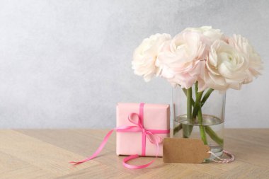 Güzel çiçekler, hediye ve tahta masada boş bir kart. Metin için boşluk