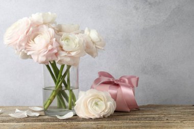 Güzel çiçekler ve ahşap masada bir hediye. Metin için boşluk