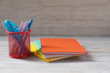 Homework. Notebooks and different stationery on light grey wooden table, closeup