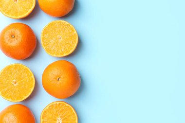 Açık mavi arka planda taze taze mandalinalar, düz uzanmış. Metin için boşluk