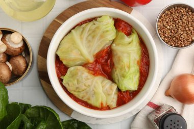 Lezzetli dolgulu lahana ruloları ve malzemeler masada, düz yatıyordu.