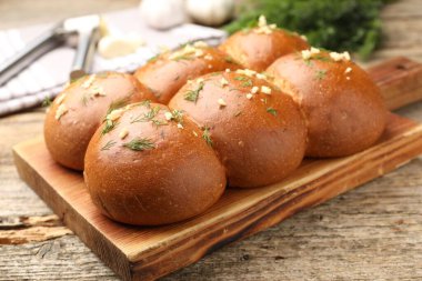 Tahta masada sarımsaklı ve dereotlu lezzetli çörekler, yakın plan.