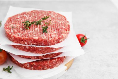 Gri masada kekik ve domatesli pişmemiş köfte, yakın plan. Metin için boşluk