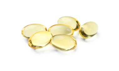 Beyaz üzerine izole edilmiş altın jelatin kapsülleri yığını