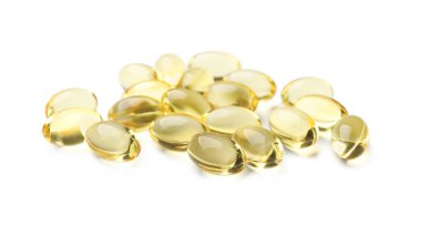 Beyaz üzerine izole edilmiş altın jelatin kapsülleri yığını