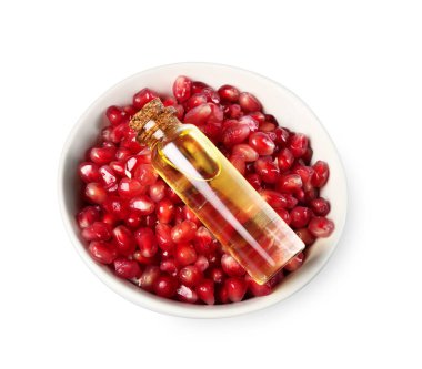 Bottle of essential oil and pomegranate seeds isolated on white, above view