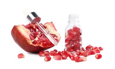 Pipette with essential oil and pomegranate seeds isolated on white