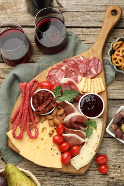 Şarküteri tahtasında bir sürü aperatif ve şarap, ahşap masa, düz yatıyordu.