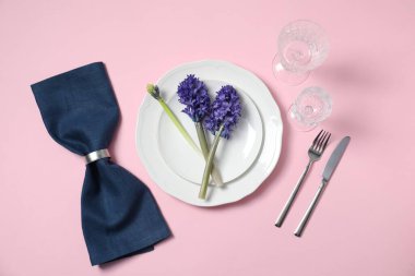 Beautiful table setting with floral decor on pink background, flat lay
