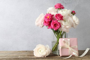 Güzel çiçekler ve ahşap masada bir hediye. Metin için boşluk