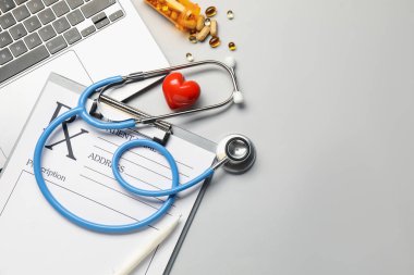 Açık gri tablo üzerinde stetoskop ve pano ile düz konum, metin için boşluk