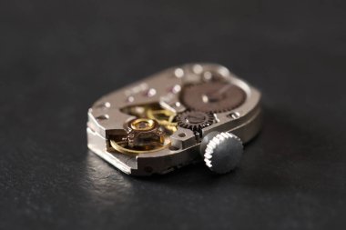 Siyah masanın üzerinde klasik kol saati mekanizması, yakın plan.