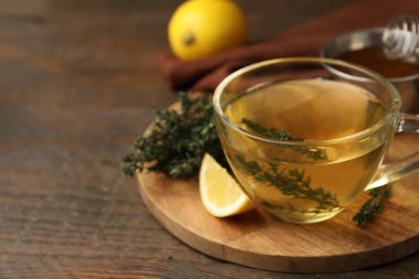 Cam bardakta taze kekik çayı ve ahşap masada bir dilim limon, yakın plan. Metin için boşluk