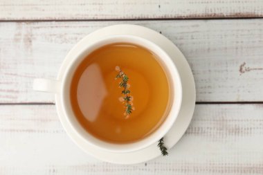 Aromatik kekik çayı bardakta açık ahşap masada, üst tarafta.