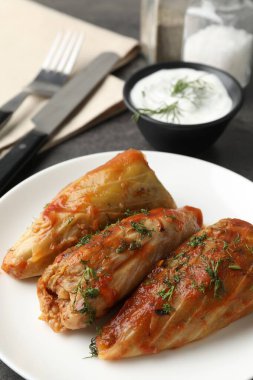 Gri masada servis edilen lezzetli lahana dürümleri, yakın plan.