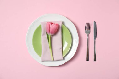 Pembe arka planda çiçek dekoru olan güzel bir masa.