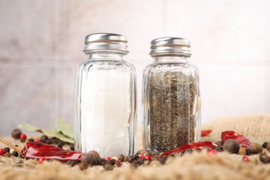 Çuval bezinde baharat olan tuzluk ve biberlikler bulanık arka planda, yakın plan