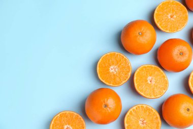 Açık mavi arka planda taze taze mandalinalar, düz uzanmış. Metin için boşluk