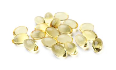 Beyaz üzerine izole edilmiş altın jelatin kapsülleri yığını