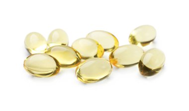 Beyaz üzerine izole edilmiş altın jelatin kapsülleri yığını