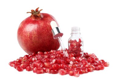 Beyaz üzerinde özgün yağ, nar ve tohumlar bulunan bir boru.