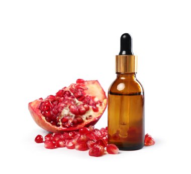 Beyaz üzerine izole edilmiş bir şişe yağ ve nar tohumu.