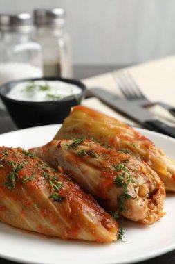 Gri masada servis edilen lezzetli lahana dürümleri, yakın plan.