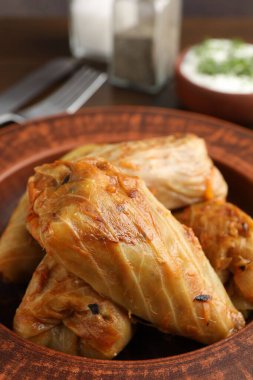 Tahta masada servis edilen lezzetli lahana dürümleri, yakın plan.