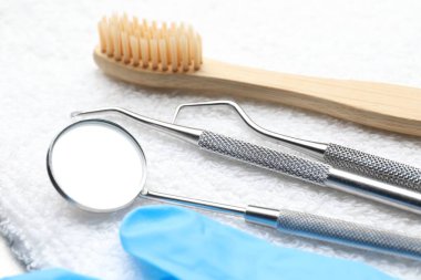 Beyaz havluda farklı diş aletleri, yakın plan.