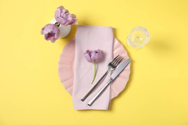 Sarı arka planda çiçek dekoru olan güzel bir masa.