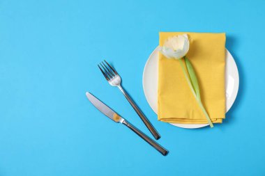 Açık mavi arka planda çiçek dekoru olan güzel bir masa. Metin için boşluk