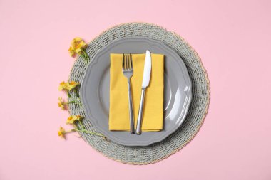 Pembe arka planda çiçek dekoru olan güzel bir masa.