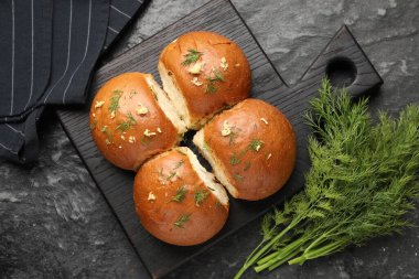 Siyah masada sarımsaklı taze çörekler ve dereotlar.