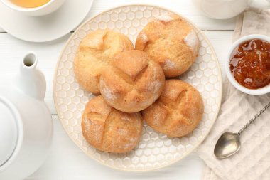 Taze çörekler, reçel ve çay beyaz ahşap masada, düz yatıyordu.