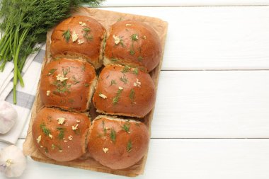 Sarımsaklı taze çörekler ve beyaz ahşap masa üzerinde dereotlu, düz. Metin için boşluk