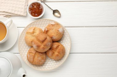 Taze çörekler, reçel ve çay beyaz ahşap masada, düz yerde. Metin için boşluk