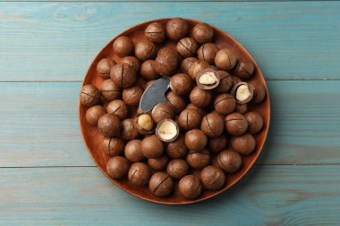 Macadamia fındığı ve metal anahtar açık mavi ahşap masa, üst görüş.